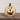Decorative pumpkin with a carved face on a wooden surface against a white wall.