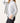 Person wearing a light gray turtleneck sweater over a dark outfit on a plain background