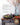 Rustic farm table with a wooden bowl and harvest salad, fresh vegetables. A large vase with natural branches with orange berries. Glassware and silverware accompanies linens. James Beard Award Winner badge.