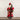 Ragon House Santa with Red Fur-Trimmed Robe. He is holding a tree and a staff. His belt is full of gifts