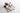 Ice cream sundae with cherry toppings and jars of jam on a white surface