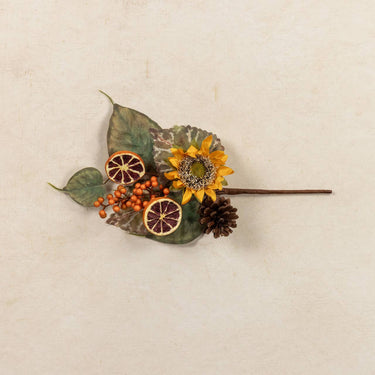 Decorative hairpin with sunflower, leaves, and dried elements on a beige background