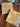 Detail The Painted Lily - Golden Tapestry stone coasters. Each one has a different tapestry design. Grey/sepia tone and white print over a golden yellow background.