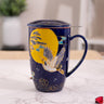 Navy blue mug with a yellow moon and crane design; sitting on a marble surface.