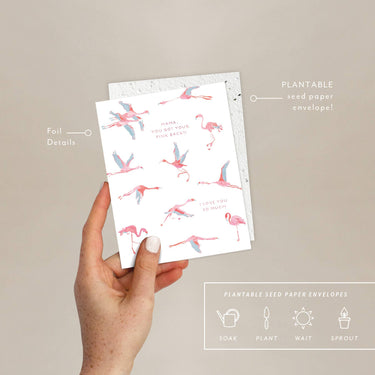 Hand holding a plantable seed paper envelope with flamingo design on a beige background