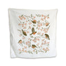 Cream tea towel with birds and blooming branches in shades of pink.