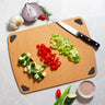 Vellum Wood Fiber Composite Cutting Board with Non-Skid Pads Shown with cut vegetables