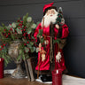 Ragon House Santa with Red Fur-Trimmed Robe. He is holding a tree and a staff. His belt is full of gifts