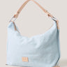 Light blue handbag with beige strap and logo on a light background