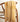 Yellow plaid blanket with tassels draped over a wooden chair against a white background