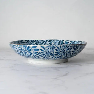 Ceramic bowl with blue floral pattern on a marble surface
