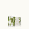 A clear glass votive candle with delicate pine needles, labeled 'Frasier Fir Pine Needle'.