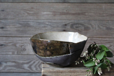Handmade bowl in shades of blue, back, brown, and cream